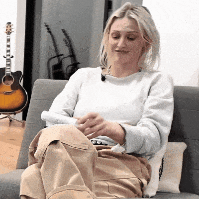 a woman sits on a couch with her legs crossed
