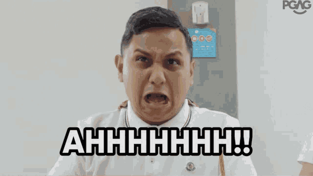 a man in a white shirt is making a funny face and says " ahhhh "