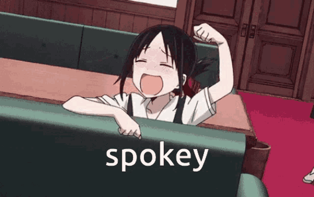 a girl is sitting at a table with her mouth open and the word spokey written below her