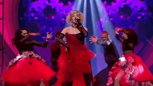 a woman in a red dress is singing on stage