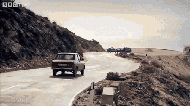 a car is driving down a road with bbc two written on the bottom right