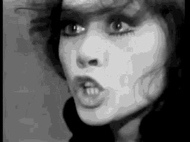 a black and white photo of a woman 's face with a serious look on her face .
