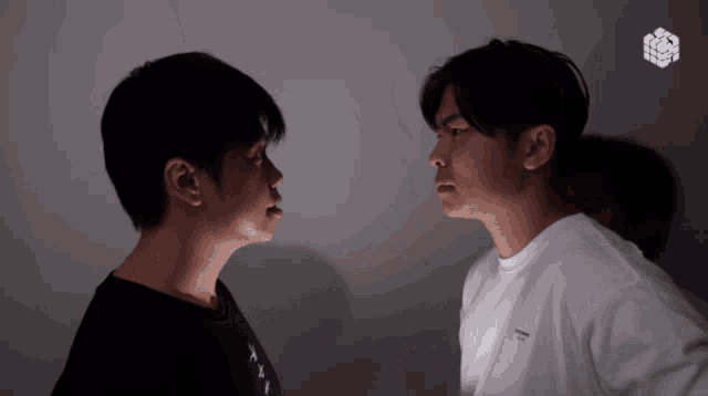a man wearing a white t-shirt that says off white looks at another man in a black shirt