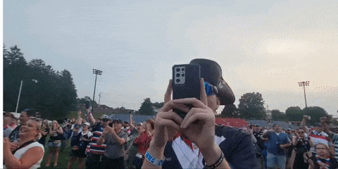 a man taking a picture of a crowd with a cell phone