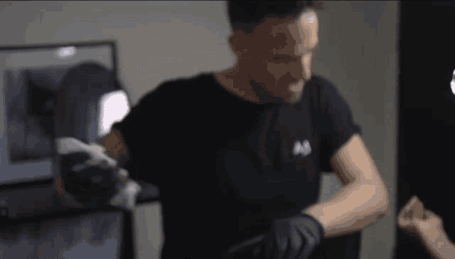 a man wearing a black t-shirt with the letter m on it