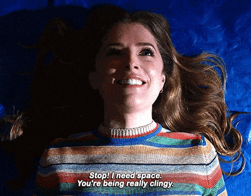 a woman in a striped sweater is smiling and laying on a blue cloth .
