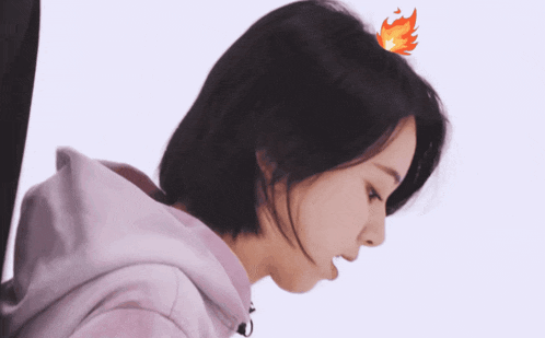 a close up of a woman 's face with a fire sticker on her head
