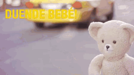 a teddy bear is standing on a street with the words duende bebe above it