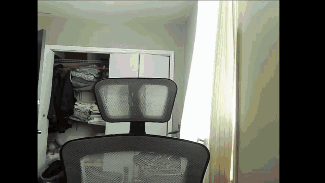 a chair in a room with a window and closet