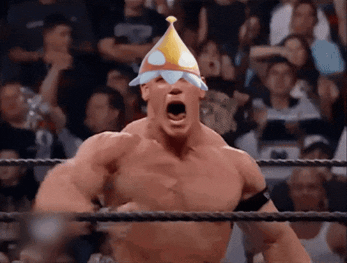 a wrestler wearing a party hat is screaming in the ring