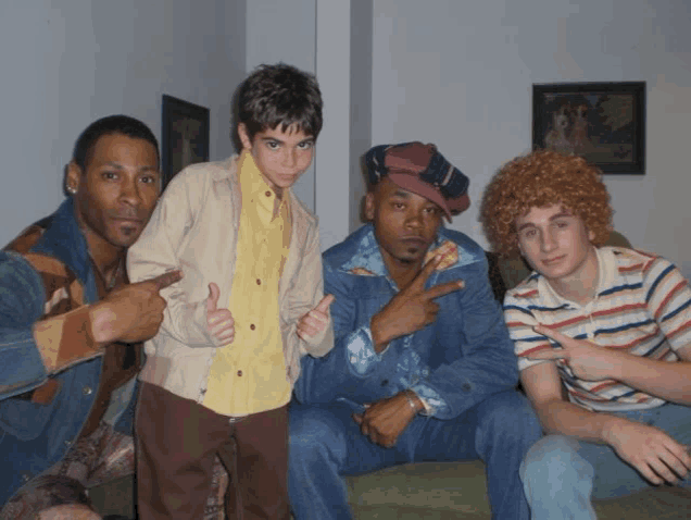 a group of young men are posing for a photo and one of them is pointing at the camera