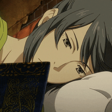 a close up of a person laying down with a book behind them
