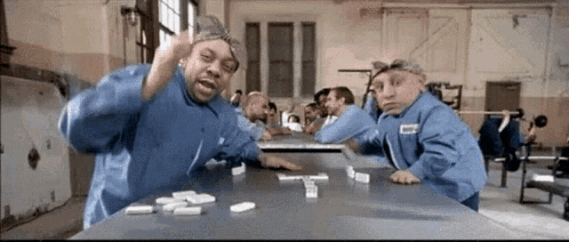 a group of men are playing dominoes at a table