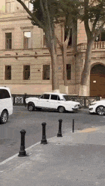 a white car is parked on the side of a street in front of a building