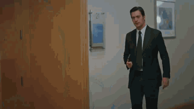 a man in a suit and tie is standing next to a woman in a room .