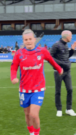 a soccer player wearing a red shirt with the number 14 on it