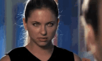 a close up of a woman 's face with yellow eyes looking at the camera .