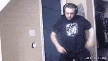 a man wearing headphones is dancing in a room with gifrun.com written on the bottom