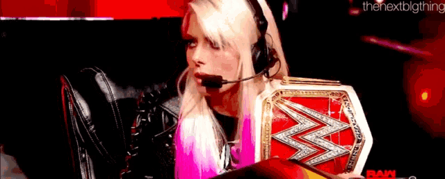 a woman is wearing headphones and holding a wrestling belt .