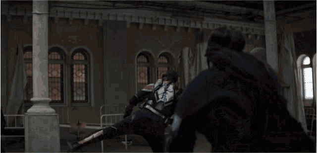 a man in a black jacket is kicking another man in the face