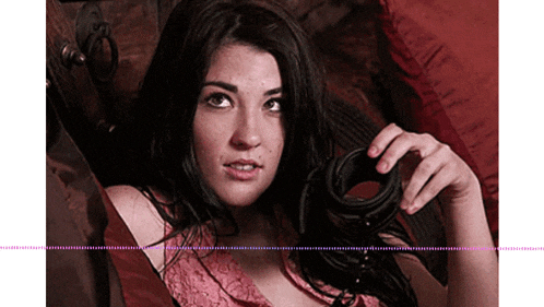 a woman in a pink lace top is holding a pair of handcuffs