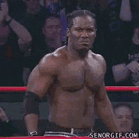 a shirtless man with braids is smiling and looking at the camera