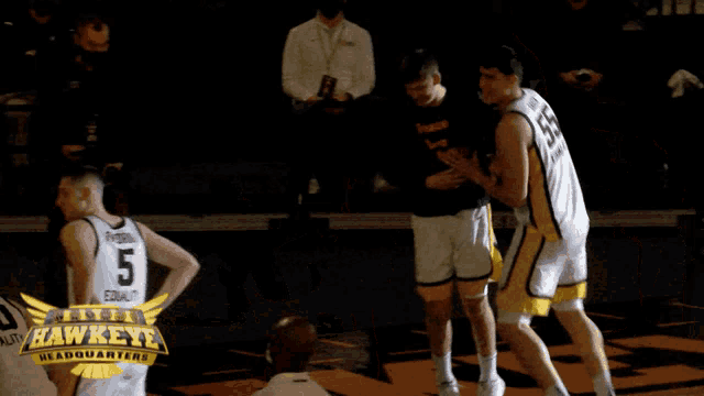a group of hawkeye basketball players are celebrating together