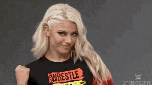 a blonde woman wearing a black t-shirt with the word wrestle on it is making a funny face .