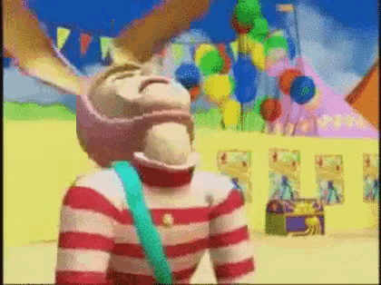 a cartoon character wearing a striped shirt and a pink hat is standing in front of balloons .