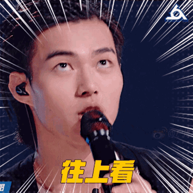 a man singing into a microphone with chinese writing on the bottom