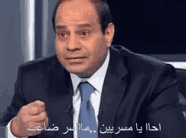a man in a suit and tie with arabic writing on his face