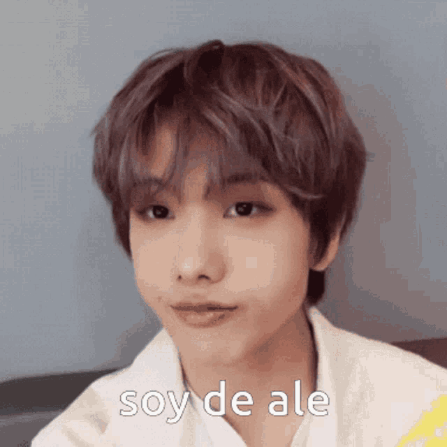 a close up of a young man 's face with the words soy de ale written on it .