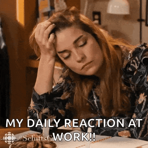 a woman is sitting at a desk with her head in her hand and the words " my daily reaction at work " below her