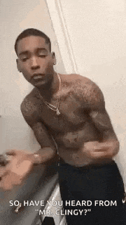 a shirtless man is standing in a bathroom talking to a woman .