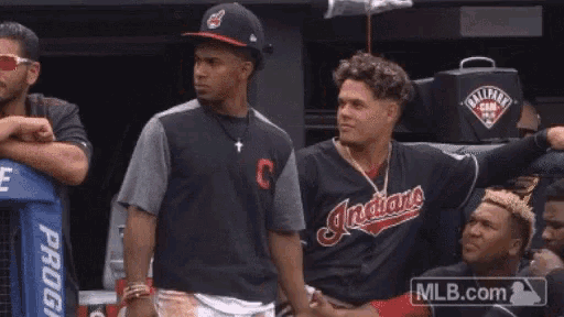 a baseball player wearing an indians jersey shakes hands with another player