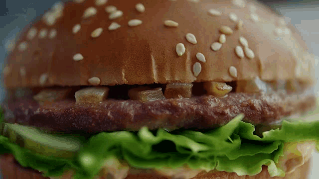 a close up of a hamburger with lettuce and bacon