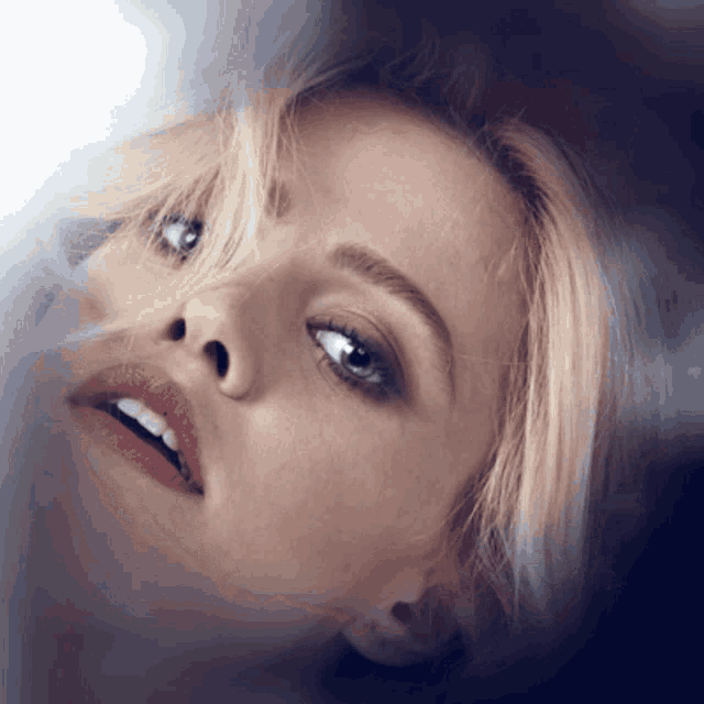 a close up of a woman 's face with her eyes closed