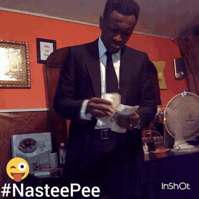 a man in a suit and tie is holding a piece of paper in front of a fan with the hashtag #nasteepee