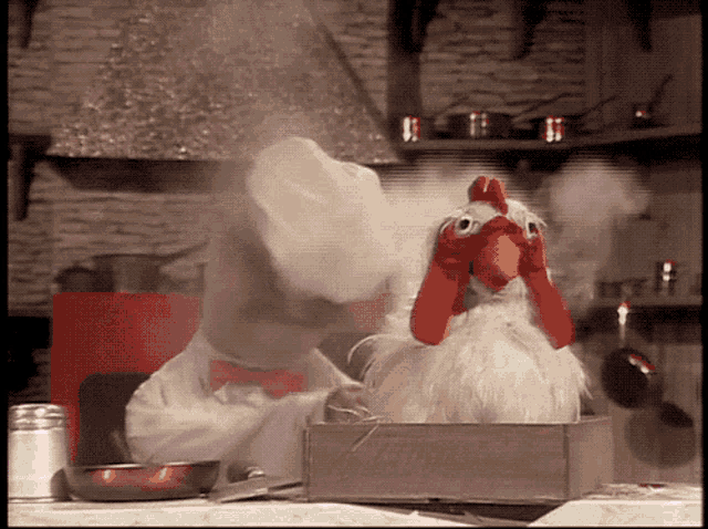 a stuffed chicken with a chef 's hat and bow tie looks out of a box