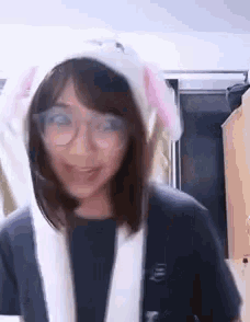 a woman wearing a bunny hat and glasses is smiling and looking at the camera .