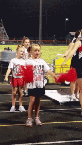a cheerleader wearing a white shirt that says ' 2014 ' on it