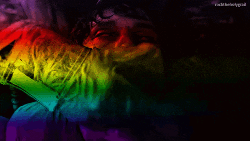 a rainbow colored image of a man 's face with the words rocktheholygrail at the bottom