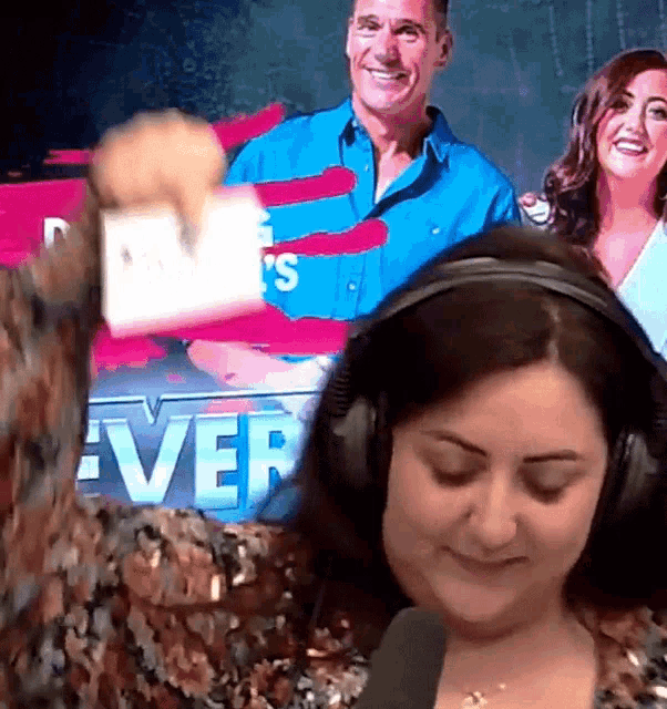 a woman wearing headphones is taking a selfie in front of a screen that says ever