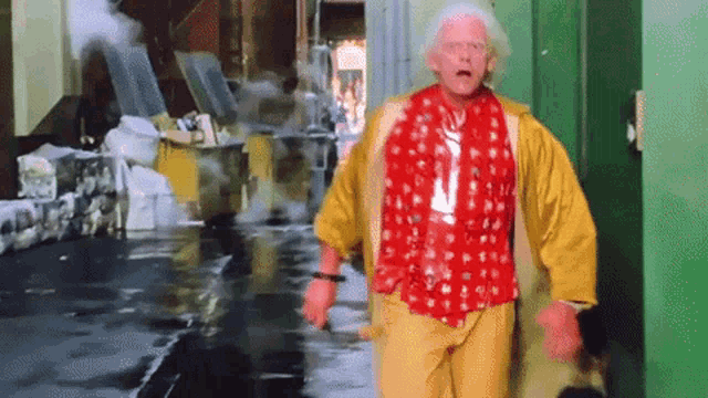 a man wearing a red shirt and yellow pants is walking down a street