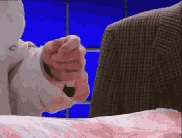 a man in a suit is pointing at a woman in a white coat .