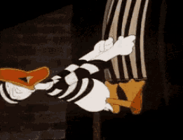 a cartoon of donald duck laying on the ground with a striped shirt on .