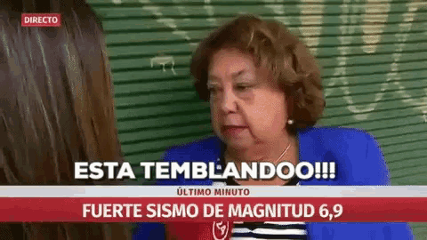a woman in a blue jacket is talking to another woman in front of a sign that says directo