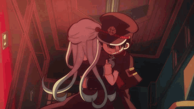 a man in a hat holds a woman in a dark room