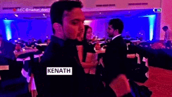a man with the name kenath on his back stands in a dark room