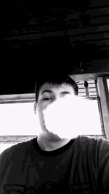 a man in a carhartt shirt is blowing smoke out of his mouth